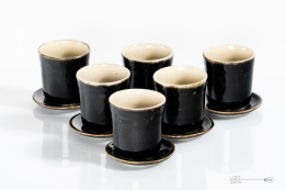 A set of ceramic glasses with saucers